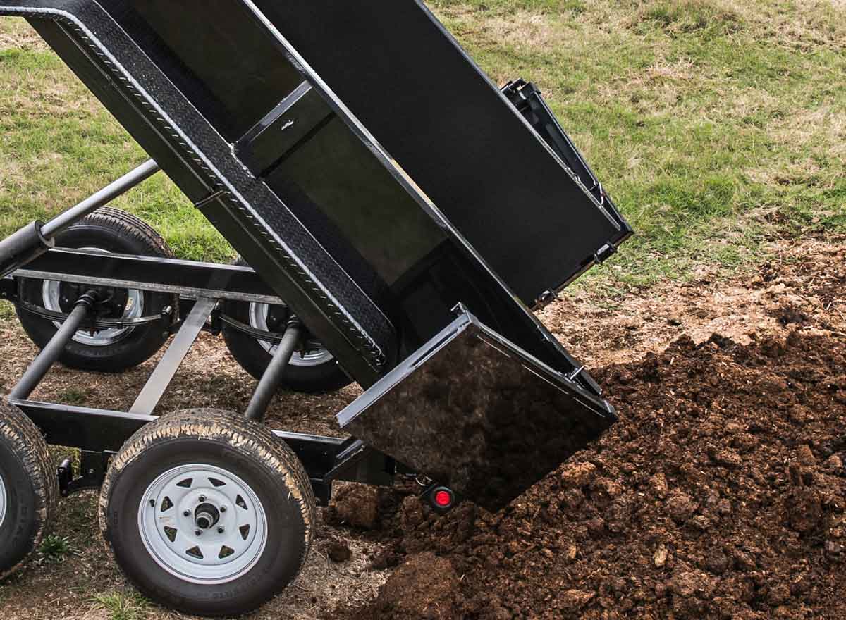 dump trailer with double rear doors is dumping dirt