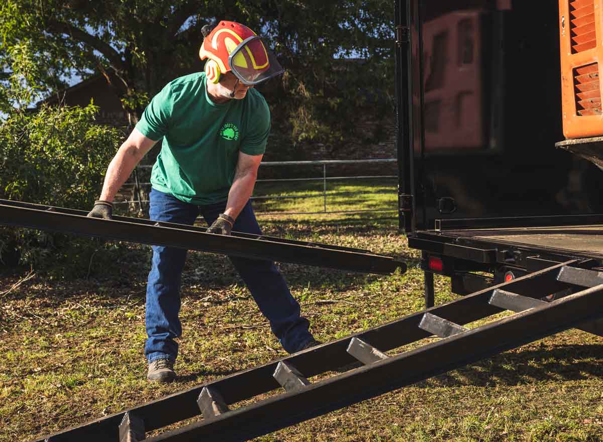 man placing ramps on trailer